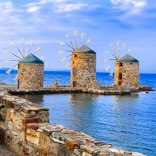 A scenic view of old windmills over sea A scenic view of old windmills over sea