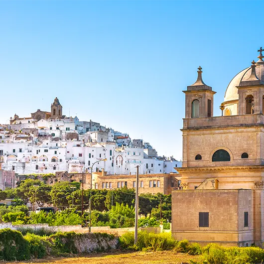 A scenic view of Ostuni white town skyline and Madonna della Grata church A scenic view of Ostuni white town skyline and Madonna della Grata church