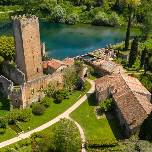 A scenic view of the ruins of the castle and tower located in the garden of Ninfa A scenic view of the ruins of the castle and tower located in the garden of Ninfa