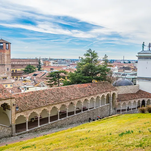 A scenic view of Udine with an arcade leading to the castle A scenic view of Udine with an arcade leading to the castle