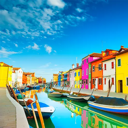A scenic view of Colorful houses on the canal in Burano island A scenic view of Colorful houses on the canal in Burano island