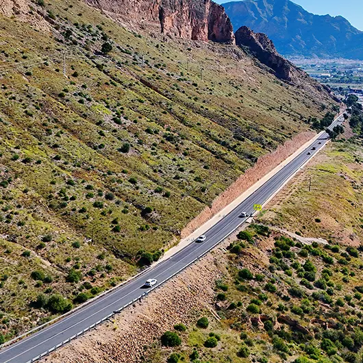 A Scenic View of winding road carving its way through rugged A Scenic View of winding road carving its way through rugged