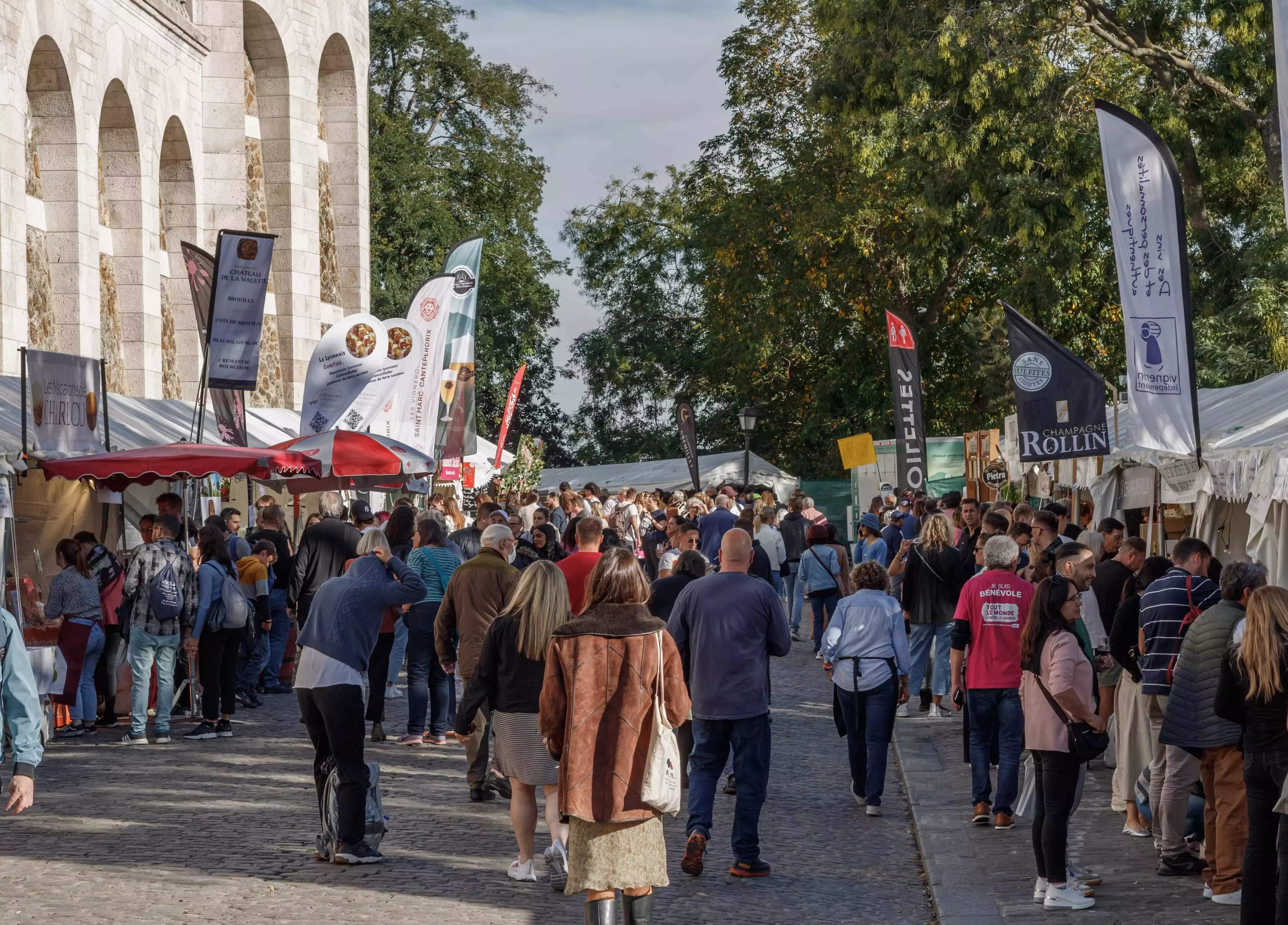 White tent stalls serving various types of wine at the Montmartre Grape Harvest Festival