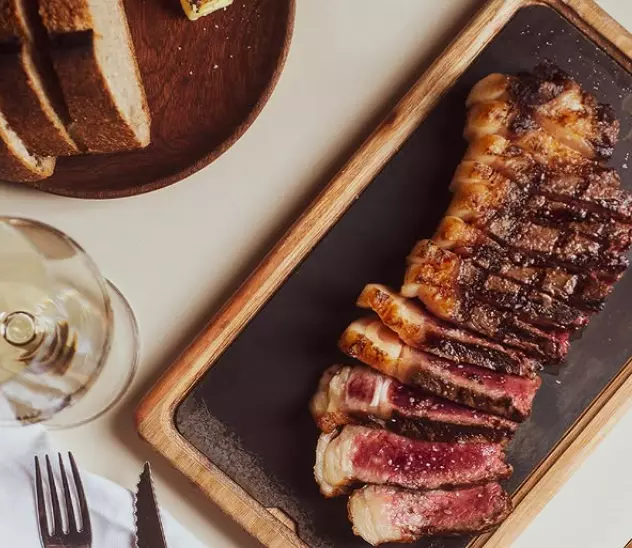 Sliced steak with a glass of red wine at Madre Rojas, Buenos Aires